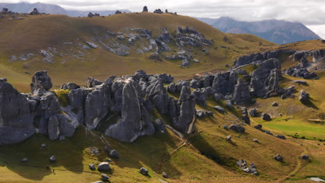 Filmische-Panoramaaufnahme-Einer-Castle-Hill-Landschaft-Mit-Herausragenden-Felsen-Und-Ländlichen-Feldern-In-Neuseeland