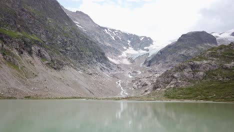 Sideway-Drone-flight-Lake-and-Stein-Glacier-with-man-on-air-mattress-in-the-Urner-Alps-in-Switzerland