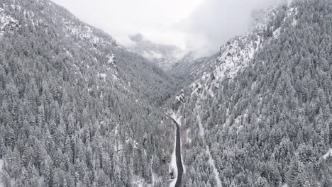 Avance-Aéreo-Sobre-Una-Carretera-Desolada-En-Un-Paisaje-Nevado
