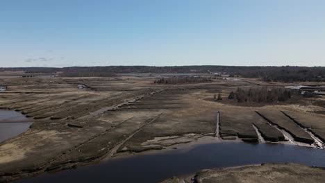 Descending-aerial-shot-of-salt-marsh-in-Scituate-during-sunny-day-with-blue-sky