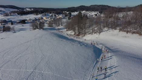 Menge-Von-Athleten,-Die-Beim-Skirennen-Im-Schneebedeckten-Winterwald-Und-An-Einem-Hellen-Sonnigen-Tag-In-Frankreich-Skifahren