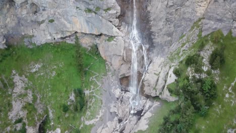 Pan-down-Drone-flight-over-waterfall-Almenbachfall-Berner-Oberland-Switzerland