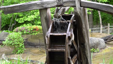 Antique-old-wooden-water-wheel-rotating-under-splashing-water-in-Namsan-Park-in-spring