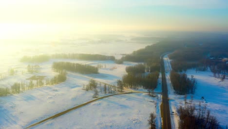 Winterpanorama-Aus-Der-Luft-Während-Des-Sonnenaufgangs-Am-Frühen-Morgen-Dunst-Eines-Nebels,-Der-Seine-Sonnigen-Strahlen-Zum-Glühen-Bringt-Und-Den-Vorort-Der-Waldautobahn-Tief-Im-Zentrum-Von-Alberta,-Kanada,-Reflektiert,-Während-Der-Nebel-In-Den-Klaren-Himmel-1-2-Schwebt