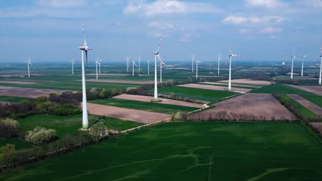 AERIAL---Wind-turbines-in-a-wind-energy-farm-in-Austria,-wide-shot-slow-left