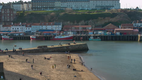 Whitby-Harbour,-Pier-and-Beach-evening-sun-with-crowds-and-fishing-and-pleasure-boats