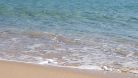 Calm-turquoise-water-hitting-sandy-beach-on-seashore-in-Southern-Sardinia,-Italy