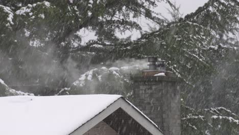Stone-chimney-smoke-blowing-into-the-wind-during-a-heavy-snowfall-in-winter
