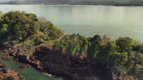 aerial-backwards-dolly-shot-of-small-rocky-tropical-island-off-the-coast-of-Koh-Chang,-Thailand