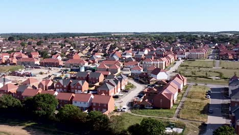 Aerial-pan-shot-looking-over-a-residential-area-of-an-English-country-village,-showing-houses,parks-and-streets