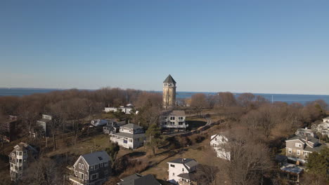 Drone-aerial-footage-of-approach-to-a-lookout-tower,-in-Hull-MA,-shows-Atlantic-ocean-beyond