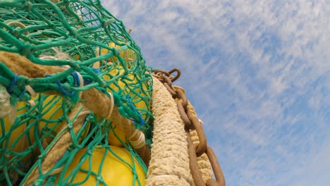 Tilt-down-shot-of-fishing-net-with-chains-and-buoys