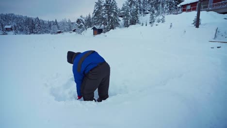 Hombre-Limpiando-La-Nieve-Profunda-Con-Una-Pala-Junto-A-Su-Perro-Mascota-En-Trondheim,-Noruega