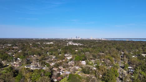 Aerial-view-over-the-Murray-Hill-suburbs,-Jacksonville-cityscape-in-the-background---pull-back,-drone-shot