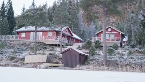 Cabin-Houses-On-Hilltop-With-Pine-Trees-At-Winter-In-Norway