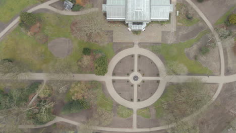 Top-down-aerial-of-old-indoor-botanic-garden-in-a-small-green-park