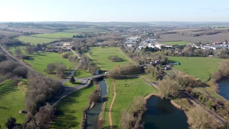 Idyllic-green-British-Canterbury-countryside-aerial-view-pull-back-above-River-Stour-Chartham-village-scenery