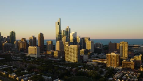 Drone-Flies-Away-from-South-Loop-Skyscrapers-during-Sunset-in-Chicago,-Illinois