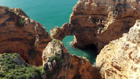 Rock-formation-Stone-Arch-"Catedral"-in-Ponta-da-Piedade-Lagos-Algarve---Aerial-Point-of-interest-Slow-orbit-top-view