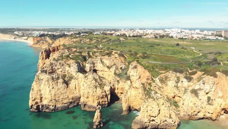 Aerial-forward-over-Atlantic-sea-approaching-cliffs,-Lagos,-Algarve,-Portugal