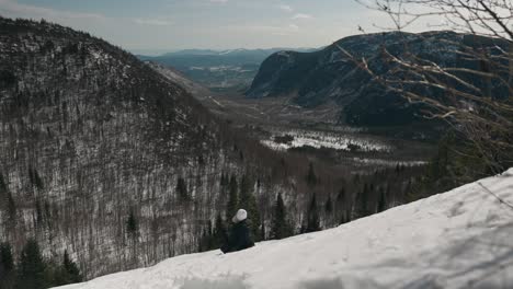 Girl-Sitting-And-Enjoying-The-View-Of-Mont-Du-Dome-Mountain-In-Quebec,-Canada-During-Winter---wide-shot