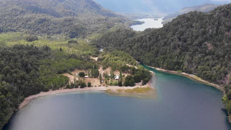 Aerial-tilt-down-to-campground-on-Espejo-Lake,-Correntoso-Lake-beyond