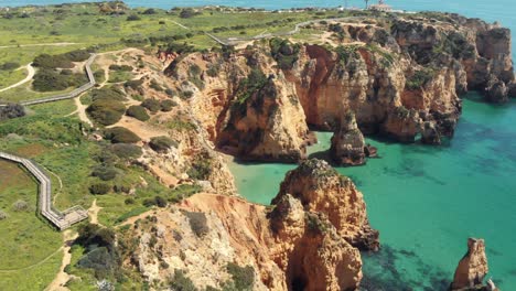 Idyllic-mediterranean-coastline-of-Ponta-da-Piedade,-Lagos,-Algarve,-Portugal---Aerial-wide-fly-over-shot