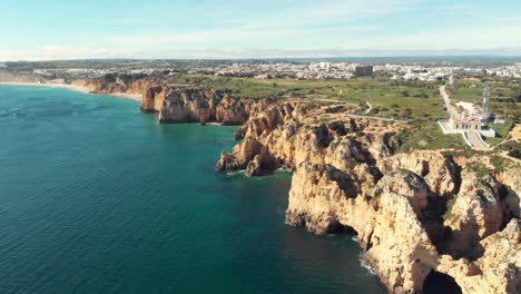 Con-Vistas-Al-Faro-Sobre-El-Acantilado-Que-Bordea-La-Costa-De-Ponta-Da-Piedade,-Lagos,-Algarve---Amplio-Plano-Aéreo