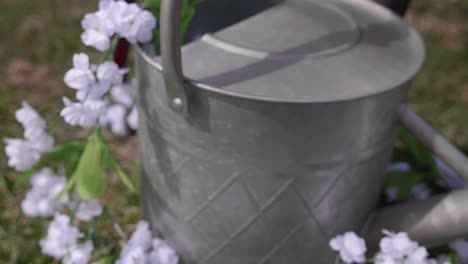 Galvanised-metal-watering-can-draped-with-flowers