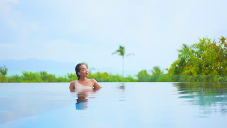 Beautiful-Woman-Relaxing-in-Infinity-Pool,-Tropical-Island-COPY-SPACE