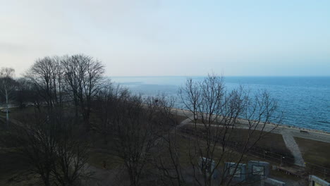Leafless-Trees-In-The-Park-With-A-View-Of-Calm-Ocean-At-Early-Morning-In-Westerplatte,-Gdansk,-Poland