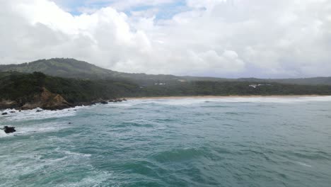 Scenic-View-Of-Beach-With-Mountains,-Blue-Sky-And-Clouds-In-Sapphire-Beach,-Coffs-Harbour,-NSW,-Australia---aerial-pullback