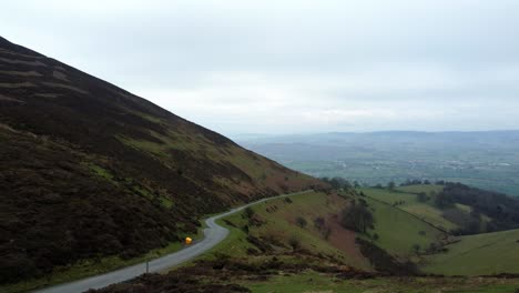 Narrow-single-rural-road-running-through-Welsh-green-mountain-valleys-landscape-dolly-left