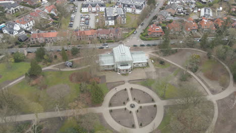 High-aerial-of-old-indoor-botanic-garden-in-a-small-green-park