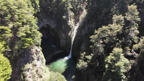 Aerial-tilt:-Stunning-Rio-Bonito-waterfall-and-cavern-in-Villa-La-Angostura-Patagonia