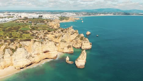 Sweeping-view-over-Rugged-sandstone-cliffs-lining-Lagos-coast,-Algarve,-Portugal---Aerial-high-wide-panoramic-shot