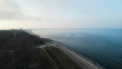 Luftfliegen-über-Der-Küste-Der-Ostsee-Bei-Sonnenuntergang-An-Nebligen-Tagen-In-Der-Westerplatte,-Polen