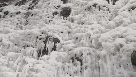 Rocky-Cliff-Covered-With-Ice-And-Icicles-At-Wintertime
