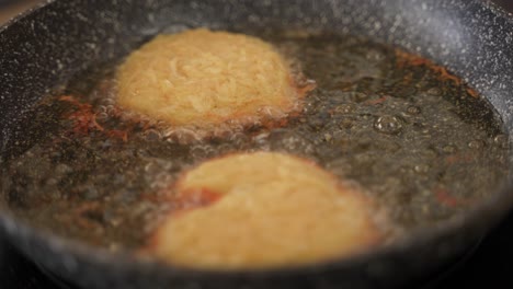 Close-up-of-frying-fresh-homemade-hashbrown-potato-puffs-in-oil