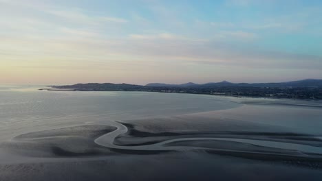 Dublin-Bay,-March-2020,-Drone-gradually-pushes-across-the-beach-at-low-tide-in-the-early-morning