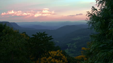 Wonderful-and-intensive-sunset-of-bold-colors,-over-a-misty-and-foggy-valley,-distant-mountains