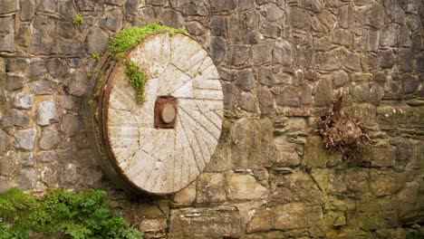 4K-old-mill-stone-decorating-a-wall-in-one-of-the-affluents-of-the-river-tone-in-Taunton-Somerset