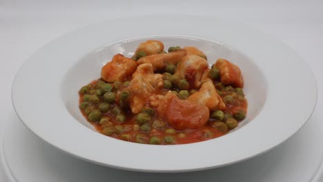 Turkey-stew-with-green-peas-in-a-white-dish-rotating