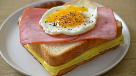 homemade-bread-toasted-cheese-topped-ham-and-fried-egg-with-pork-sausage-for-breakfast