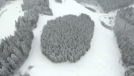 Drone-shot-flying-over-empty-ski-slopes-on-grey-winter-day,-Czech-Republic