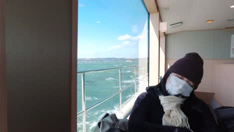 Young-tourist-sleeping-inside-moving-ship-while-wearing-facemask