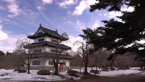 Wide-open-view-of-Hirosaki-Castle-during-winter-with-person-walking-castle-grounds