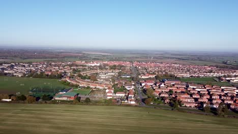 Arial-dolly-shot-over-the-a-countryside-village-in-the-southeast-of-England,-bright-sunny-day