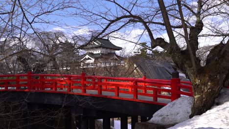 Slow-motion-handheld-view-of-typical-red-bridge-in-front-of-Japanese-castle