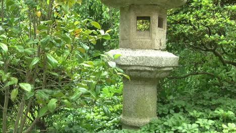 Camera-jibs-down-from-stone-lantern-to-side-angle-view-of-rainwater-basin-in-a-Japanese-garden
